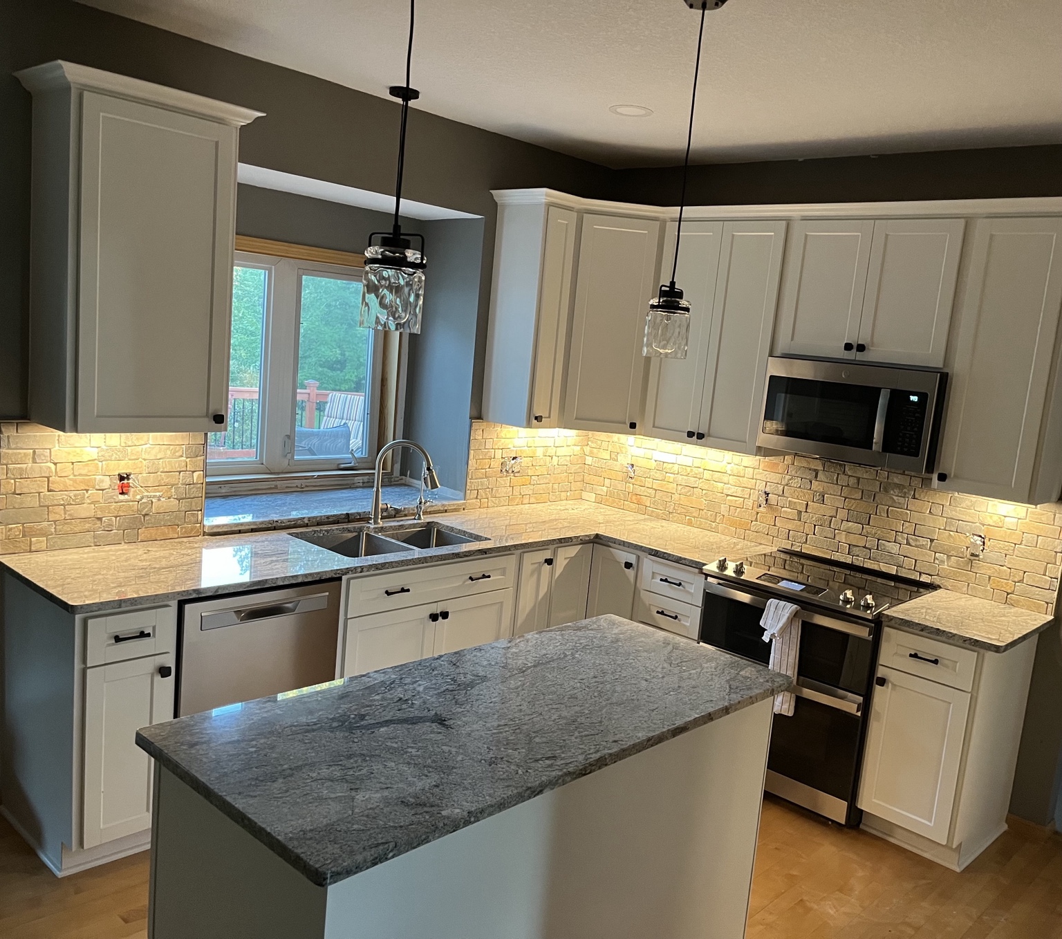 Travertine backsplash with under cabinet lighting